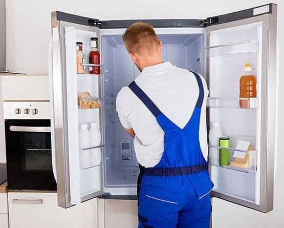 Technician inspecting a refrigerator